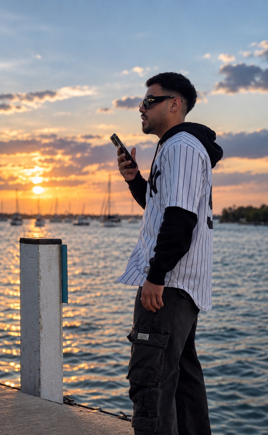 Adrian Godoy al teléfono en un muelle de Miami al atardecer